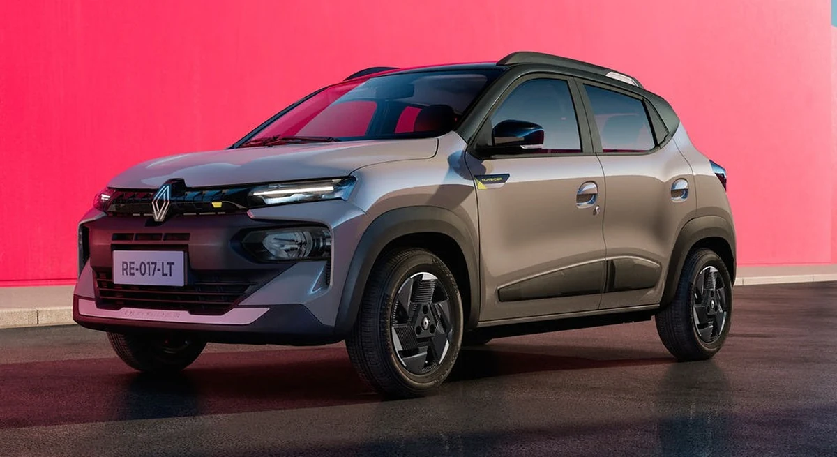 Renault Kwid 2027 Outsider cinza com teto preto, visto de frente em ângulo três quartos, em estúdio com parede rosa
