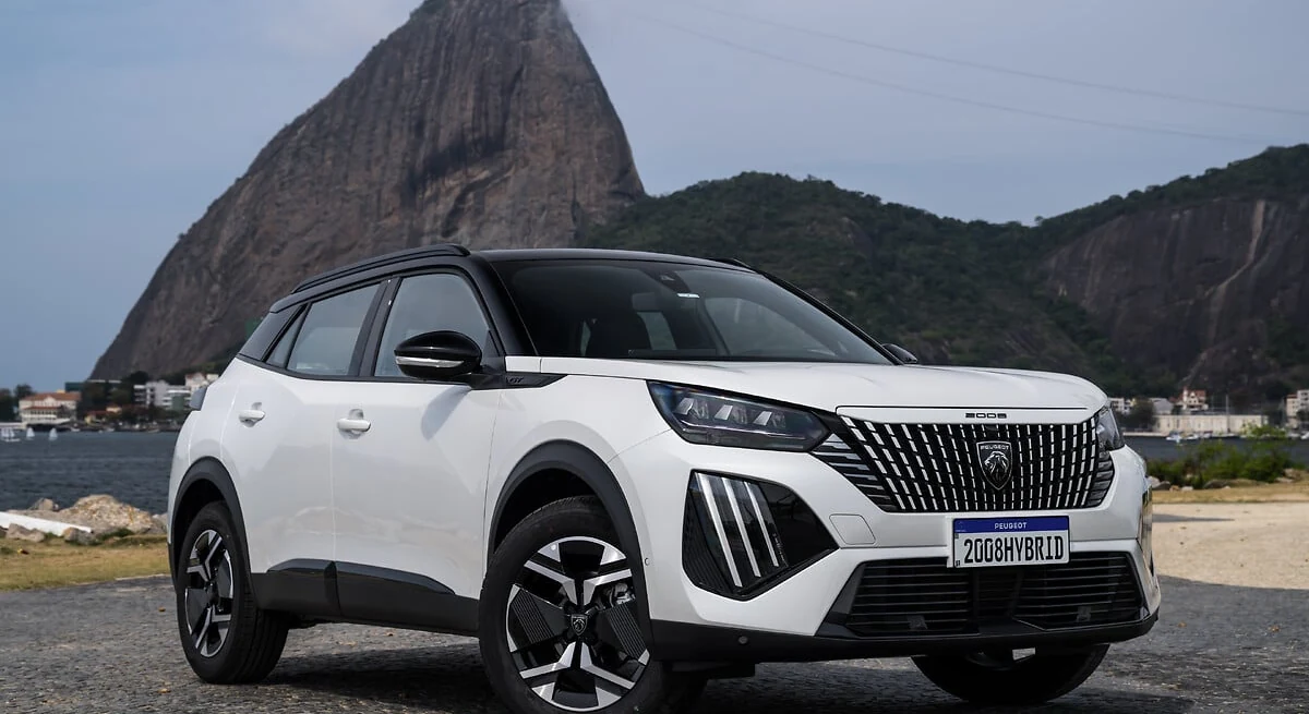 Peugeot 2008 Hybrid branco visto de frente em ângulo três quartos, com o Pão de Açúcar ao fundo