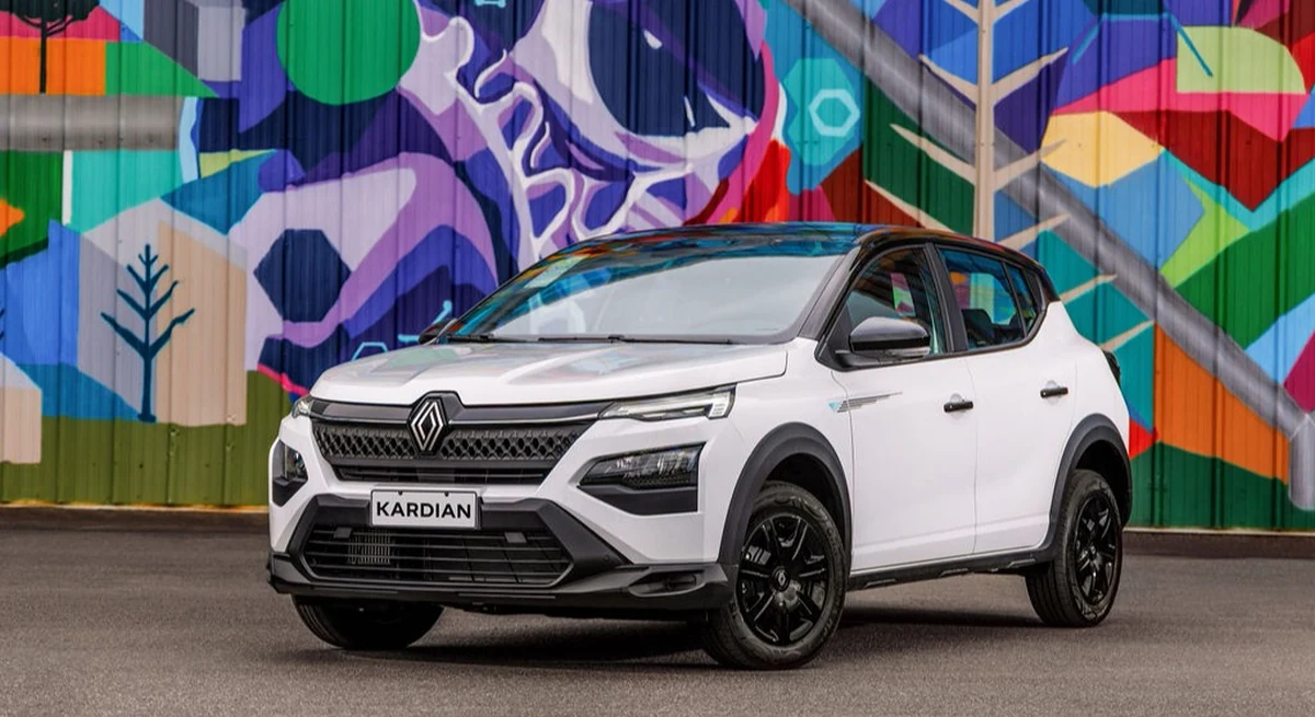 Renault Kardian Vibe 2027 branco com rodas pretas, visto de frente em ângulo três quartos, diante de um mural colorido