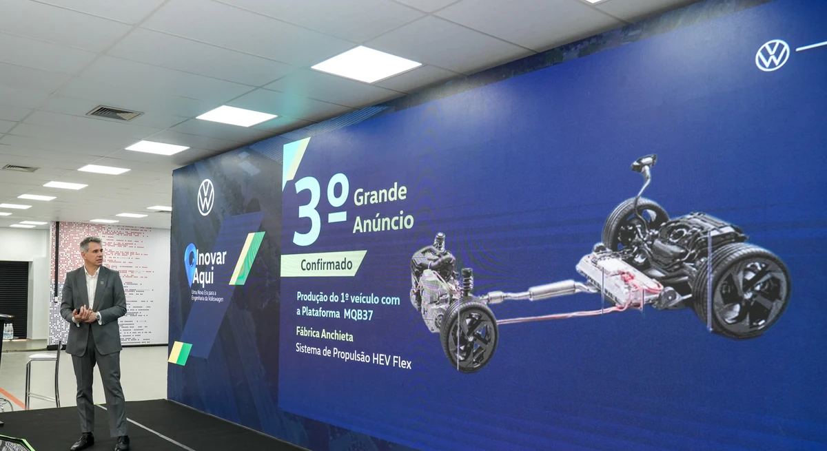 Executivo da Volkswagen no palco da fábrica Anchieta diante do telão que confirma a produção do primeiro veículo da plataforma MQB37 com sistema de propulsão HEV flex